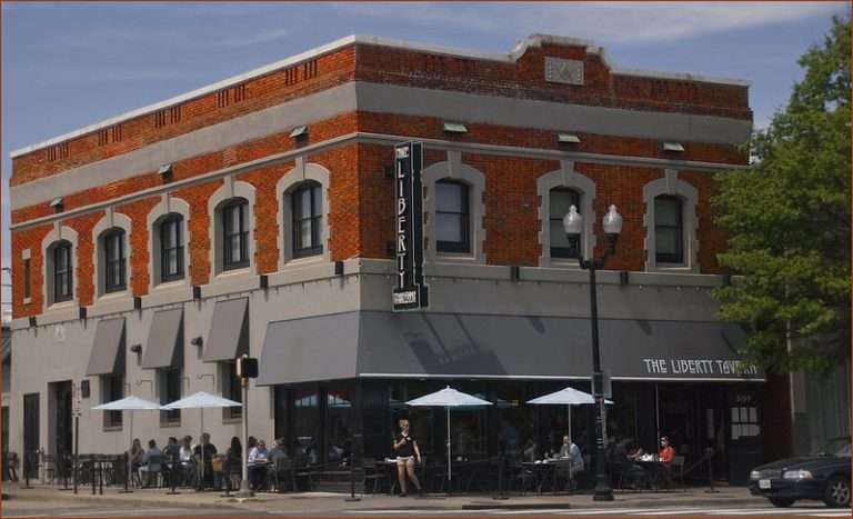 Arlington VA 43 Brick building with outdoor seating, umbrellas, and signs reading "The Liberty Tavern".