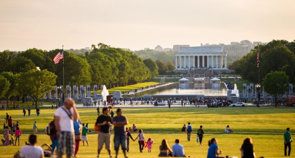 Tourists enjoy the lawn during a sunny day in front of the Lincoln Memorial on the National Mall.