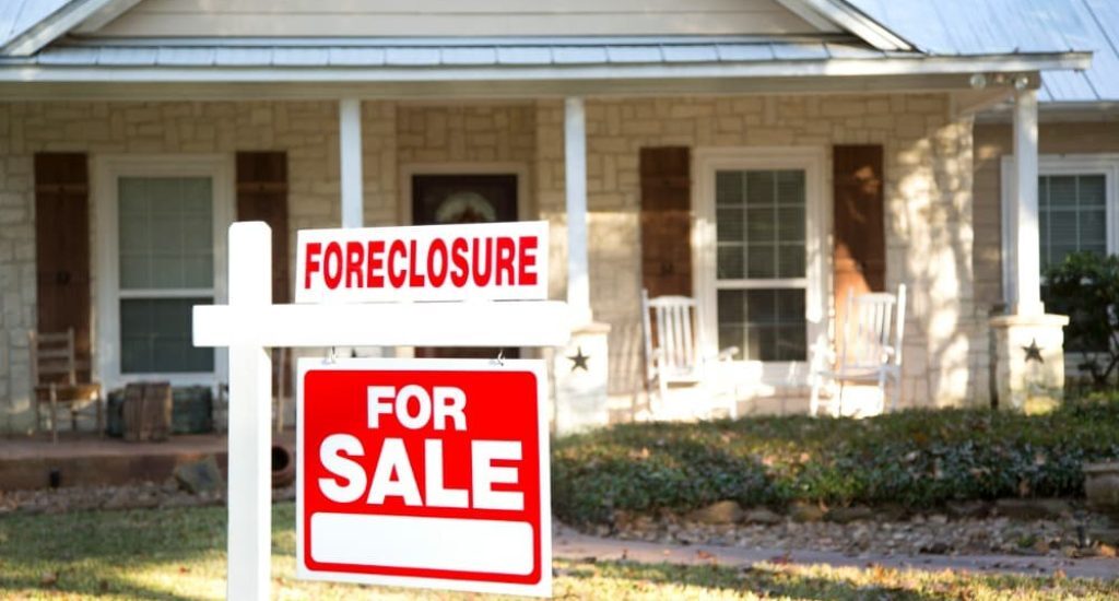 Investing in foreclosures, like this house with a foreclosure sign out front, can help you get started in the D.C. real estate market
