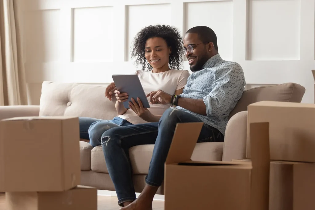 Happy black couple looking at their iPad displaying a great rental valuation for their property.