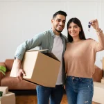 Happy young Indian couple unpacking boxes in their new home in Washington DC.