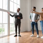 Nomadic property manager showing a newly listed property for rent to a young Indian couple.