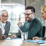 Mortgage lender discussing great terms for new young couple buying home.