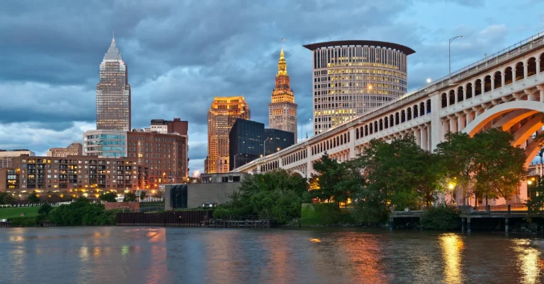 Downtown Cleveland skyline and illuminated bridge reflecting on the Cuyahoga River at dusk