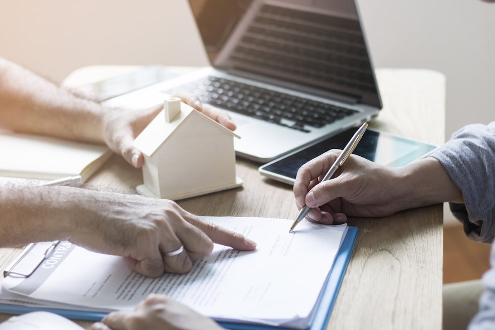 Signing a contract to a house they bought using the 2% Rule.