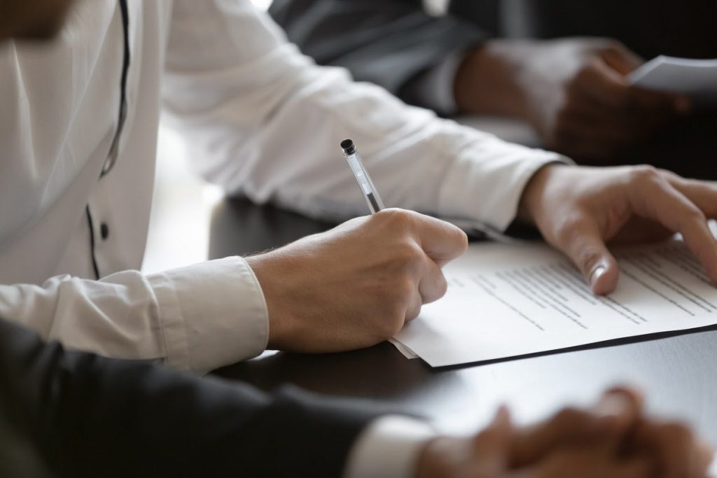 Businesswoman signing over a rental property after receiving a business license.